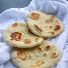 three pita breads sitting on top of a white towel next to each other