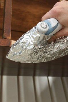 a person is using an electronic device to wrap tin foil around the edge of a table