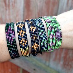 a person's arm with several bracelets on top of it and a wooden fence in the background