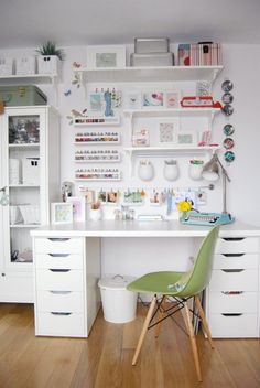 a white desk topped with lots of drawers next to a shelf filled with crafting supplies