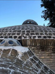 an old brick building with a dome shaped window on the top and round windows in the middle