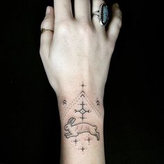 a person's hand with a small tattoo on the wrist and an arrow in the middle