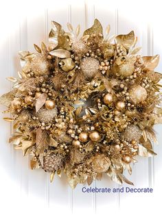 a christmas wreath with gold ornaments and berries on it, hanging on a white door