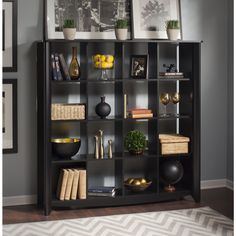 a black bookcase with books and pictures on it