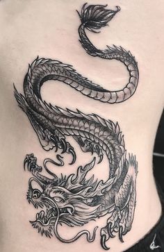 a woman's stomach with a dragon tattoo on it