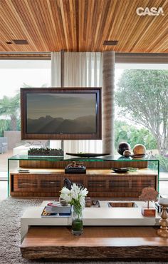 a living room with a large flat screen tv on top of a wooden coffee table