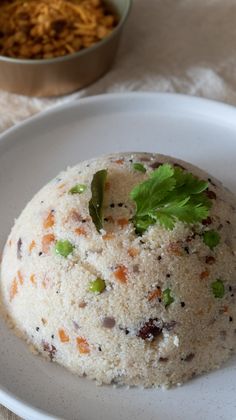 a white plate topped with food next to a bowl