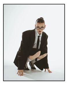 a woman in a suit and tie kneeling down