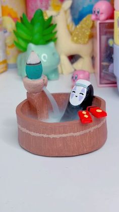 there is a small toy boat with sushi in it and other toys behind it