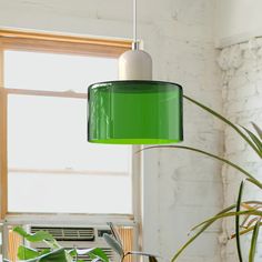 a green lamp hanging over a dining room table