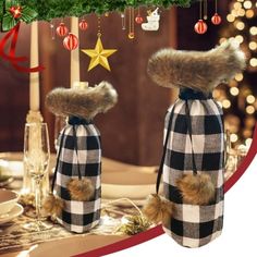 two stuffed animals are dressed in plaid and furs, with christmas decorations on the table behind them