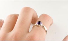 "A simple ring with a bright purple natural amethyst cabochon that is bezel set in sterling silver. The amethyst, mined in Brazil, is 5mm round (about 1/4\" inch). A minimal and elegant design durable enough for everyday wear. The sterling silver is hypoallergenic nickel free. Size adjustments are available upon request- just message us! Our jewelry was designed and made by Jan Palombo of Great Falls Metalworks who has been making jewelry in the USA since 1968. The collection in this shop is of Minimalist Purple Gemstone Birthstone Ring, Minimalist Purple Gemstone Rings, Minimalist Purple Birthstone Ring, Minimalist Silver Amethyst Ring, Minimalist Purple Amethyst Ring For Anniversary, Modern Purple Sterling Silver Ring, Amethyst Ring With Bezel Setting For Promise, Elegant Sterling Silver Amethyst Cabochon Ring, Elegant Sterling Silver Cabochon Amethyst Ring