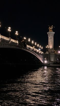 the bridge is lit up at night by street lights