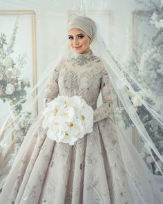 a woman in a wedding dress holding a bouquet of flowers and posing for the camera