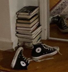 Pair of black converse sitting by a mirror with one tipped over on its side and a small pile of note books in the corner behind them, very aesthetic very cool Black Converse, Converse, Books, Black