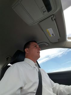 a man sitting in the back seat of a car wearing a tie and dress shirt