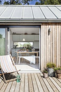 a deck chair sitting on top of a wooden floor next to a table and chairs