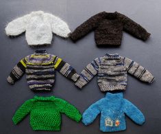 four knitted sweaters and hats on a table