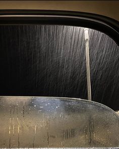 the back window of a car with rain falling on it