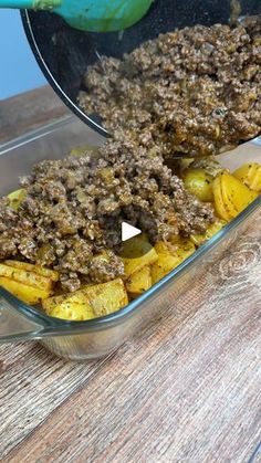 a casserole dish with meat and potatoes in it on a wooden table top