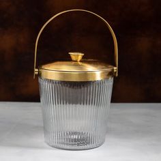 a small glass basket with a gold lid