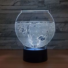 an illuminated fish bowl on a wooden table