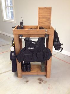 a police vest sitting on top of a wooden table next to a pair of boots