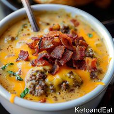 a close up of a bowl of soup with bacon and cheese in it on a table