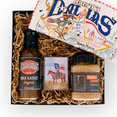 an open gift box containing two bottles of bbq sauce, salt and seasoning