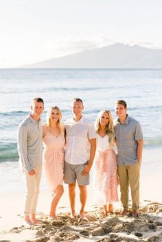 a group of people standing on top of a sandy beach