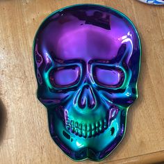 a purple and green skull shaped plate sitting on top of a wooden table