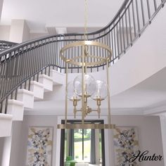 a chandelier hanging from the ceiling in a living room next to a staircase