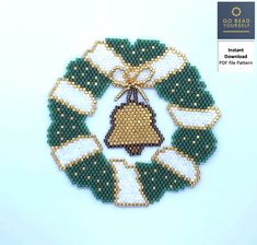 a cross stitch christmas ornament hanging on a white wall next to a blue background