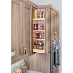 an open cabinet door in a kitchen with spices and condiments on the shelves