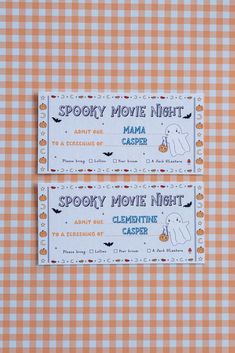 two tickets for spooky movie night on a checkered tablecloth with pumpkins