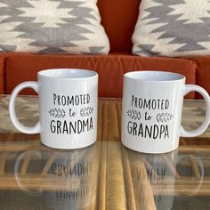 two coffee mugs sitting on top of a glass table