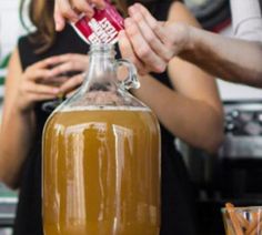 a person is pouring something into a bottle