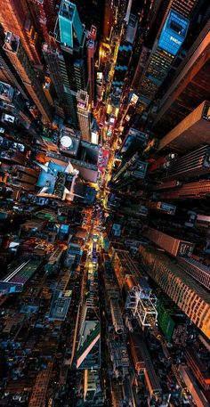 an aerial view of a city at night time with lots of lights and tall buildings