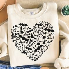 a t - shirt with the word boo on it and various items surrounding it in front of a pair of jeans