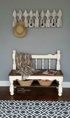 a white bench sitting in front of a wall with a hat on top of it