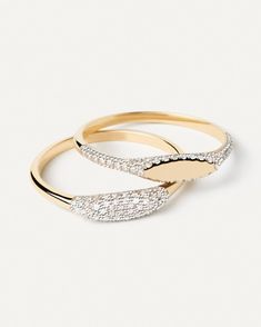 two gold rings with diamonds on them