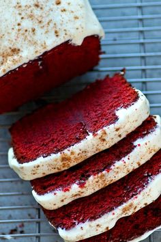 red velvet cake with white frosting and sprinkles on a cooling rack