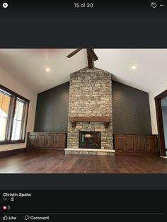 a large room with wood floors and a fireplace