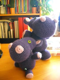 two crocheted elephants sitting on top of a wooden table