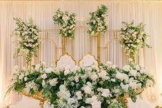 an elaborately decorated table with white flowers and greenery