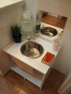 a bathroom sink with two bowls on top of it next to a wooden cutting board