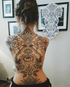 the back of a woman's body with tattoos on her upper and lower back