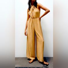 Halter Jumpsuit With Front Opening At Waist, Elastic At Black, Wide Leg And Open Back. Chic Beige Strapless Jumpsuit For Summer, Chic One-piece Summer Bottoms, Elegant Strapless Summer Jumpsuit By Zara, Zara Jumpsuits And Rompers For Summer Day Out, Zara Jumpsuits And Rompers For Summer Vacation, Zara Summer Jumpsuits And Rompers For Vacation, Zara Jumpsuit For Summer Day Out, Sleeveless Beach Jumpsuits And Rompers By Zara, Sleeveless Zara Jumpsuits And Rompers For Vacation