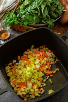 vegetables are being cooked in a pan on the table