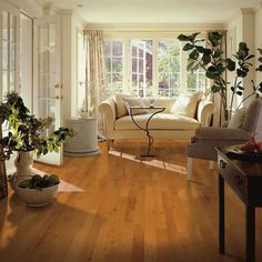 a living room filled with furniture and a large mirror on the wall next to it